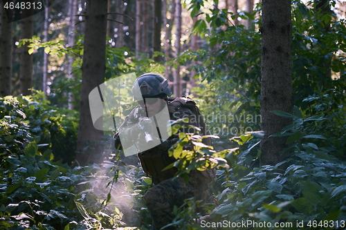 Image of soldier in action aiming  on weapon  laser sight optics