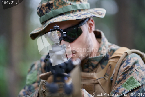 Image of soldier in action aiming  on weapon  laser sight optics