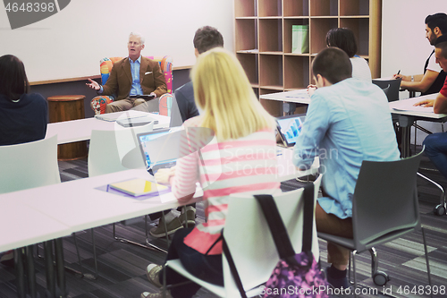 Image of teacher with a group of students in classroom