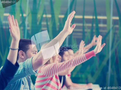 Image of students group raise hands up on class