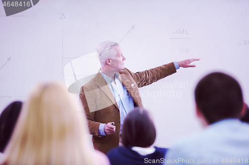 Image of teacher with a group of students in classroom