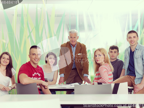 Image of portrait of in teacher in classroom with students group in backg