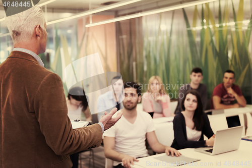 Image of teacher with a group of students in classroom