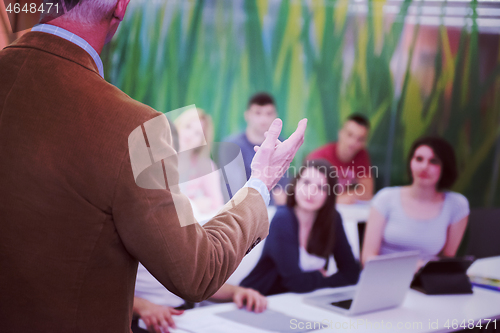 Image of teacher with a group of students in classroom