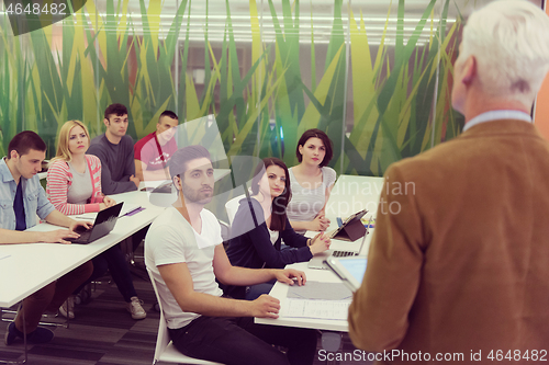 Image of teacher with a group of students in classroom