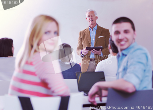 Image of teacher with a group of students in classroom