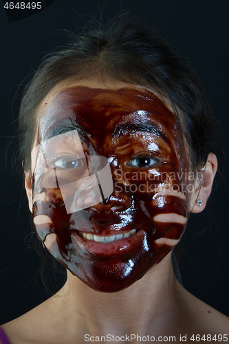 Image of young asian girl having fun with a chocolate mask