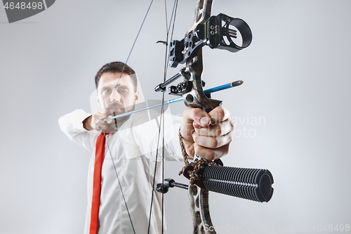 Image of Businessman aiming at target with bow and arrow, isolated on white background