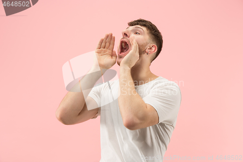 Image of Isolated on pink young casual man shouting at studio