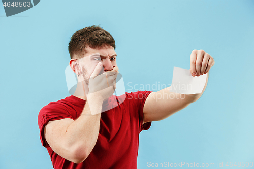 Image of Young boy with a surprised expression bet slip on blue background