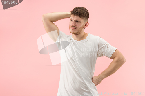 Image of Beautiful man looking suprised and bewildered isolated on pink