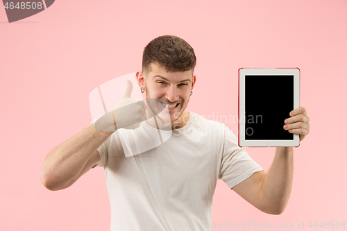 Image of portrait of smiling man pointing at laptop with blank screen isolated on white