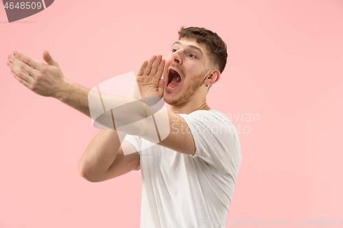 Image of Isolated on pink young casual man shouting at studio