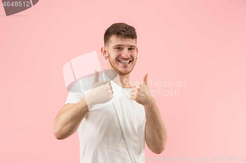 Image of The happy businessman standing and smiling against pink background.