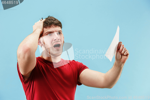 Image of Young boy with a surprised expression bet slip on blue background