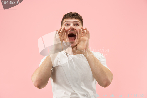 Image of Isolated on pink young casual man shouting at studio