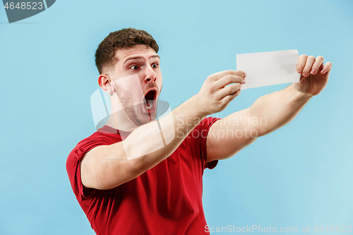 Image of Young boy with a surprised expression bet slip on blue background