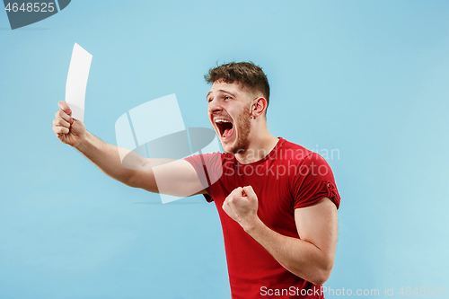 Image of Young boy with a surprised expression bet slip on blue background