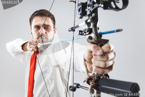 Image of Businessman aiming at target with bow and arrow, isolated on white background