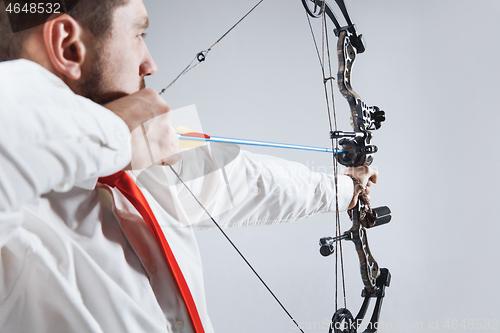 Image of Businessman aiming at target with bow and arrow, isolated on white background