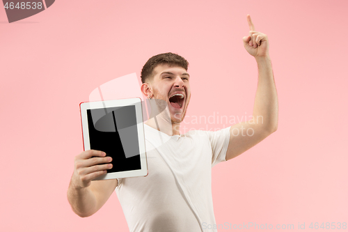 Image of portrait of smiling man pointing at laptop with blank screen isolated on white