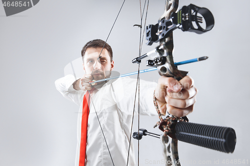 Image of Businessman aiming at target with bow and arrow, isolated on white background