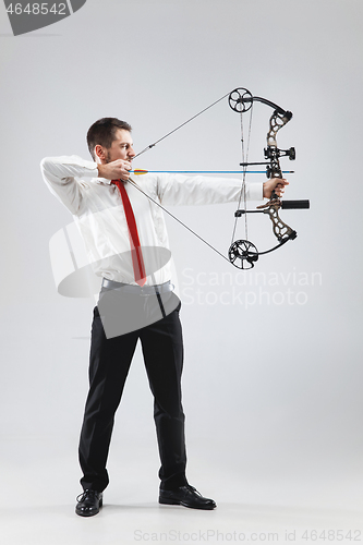 Image of Businessman aiming at target with bow and arrow, isolated on white background