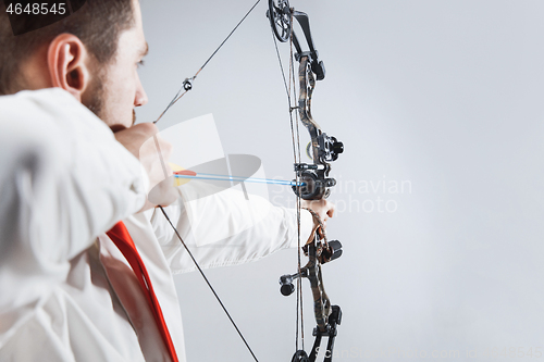 Image of Businessman aiming at target with bow and arrow, isolated on white background