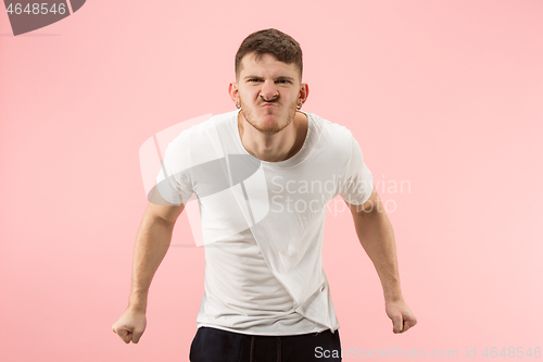 Image of The young emotional angry man screaming on pink studio background