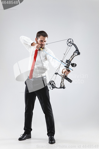 Image of Businessman aiming at target with bow and arrow, isolated on white background