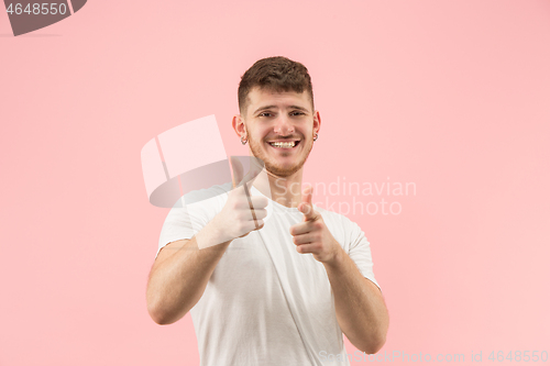 Image of The happy businessman standing and smiling against pink background.