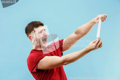 Image of Young boy with a surprised expression bet slip on blue background