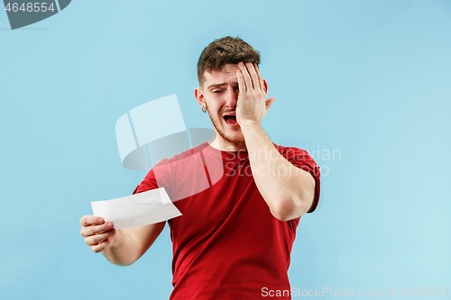 Image of Young boy with a surprised expression bet slip on blue background