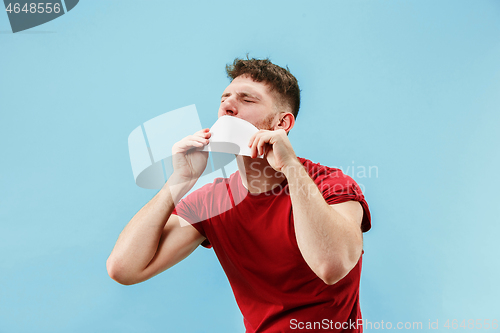 Image of Young boy with a surprised expression bet slip on blue background