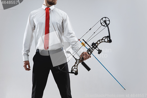 Image of Businessman aiming at target with bow and arrow, isolated on white background