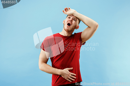 Image of Man having headache. Isolated over blue background.