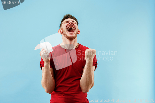 Image of Young boy with a surprised expression bet slip on blue background