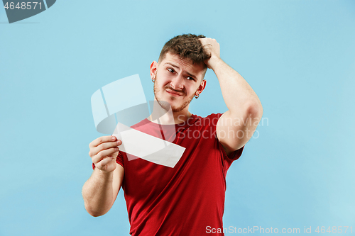 Image of Young boy with a surprised expression bet slip on blue background