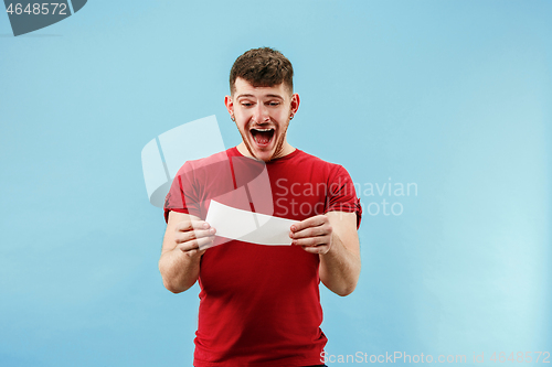 Image of Young boy with a surprised expression bet slip on blue background