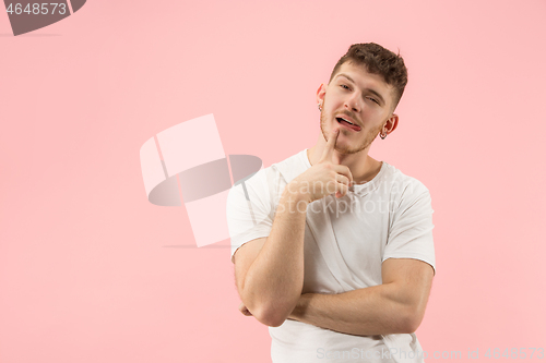 Image of Young serious thoughtful businessman. Doubt concept.