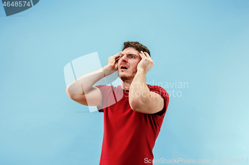 Image of Young boy with a surprised expression bet slip on blue background