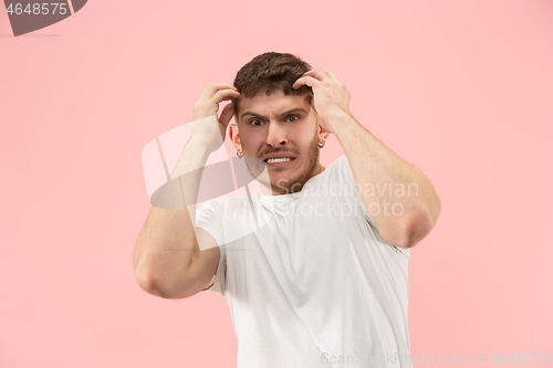 Image of Beautiful man looking suprised and bewildered isolated on pink