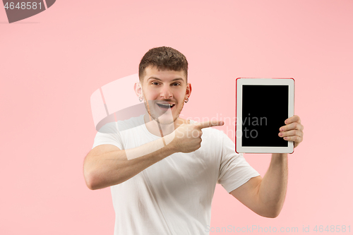 Image of portrait of smiling man pointing at laptop with blank screen isolated on white