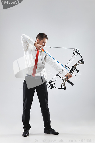 Image of Businessman aiming at target with bow and arrow, isolated on white background