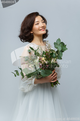 Image of beautiful girl in white dress with big bouquet