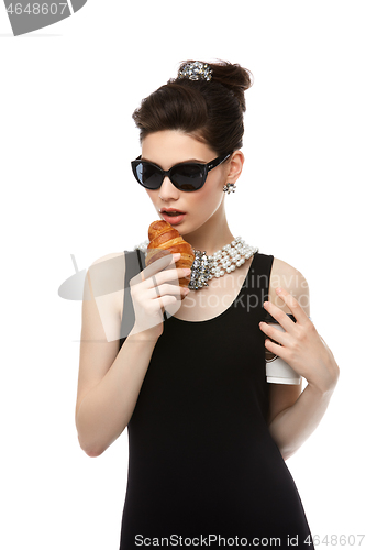 Image of beautiful young woman in retro style with croissant