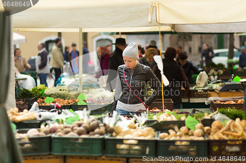 Image of Woman buying vegetable at local food market. 