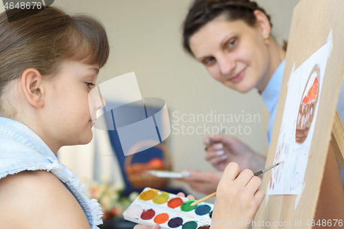 Image of Teacher looks at how a student draws still life