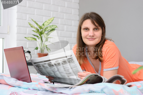 Image of The girl woke up in the morning and lying in bed began to look for work