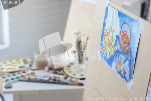 Image of artist\'s workplace with an easel on which hangs still life